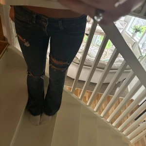 Kate Moss jeans med slitningar - Säljer ett par snygga lågmidjade jeans från Kate Moss. midjemått rakt över 38 cm, innerbenslängden 77cm