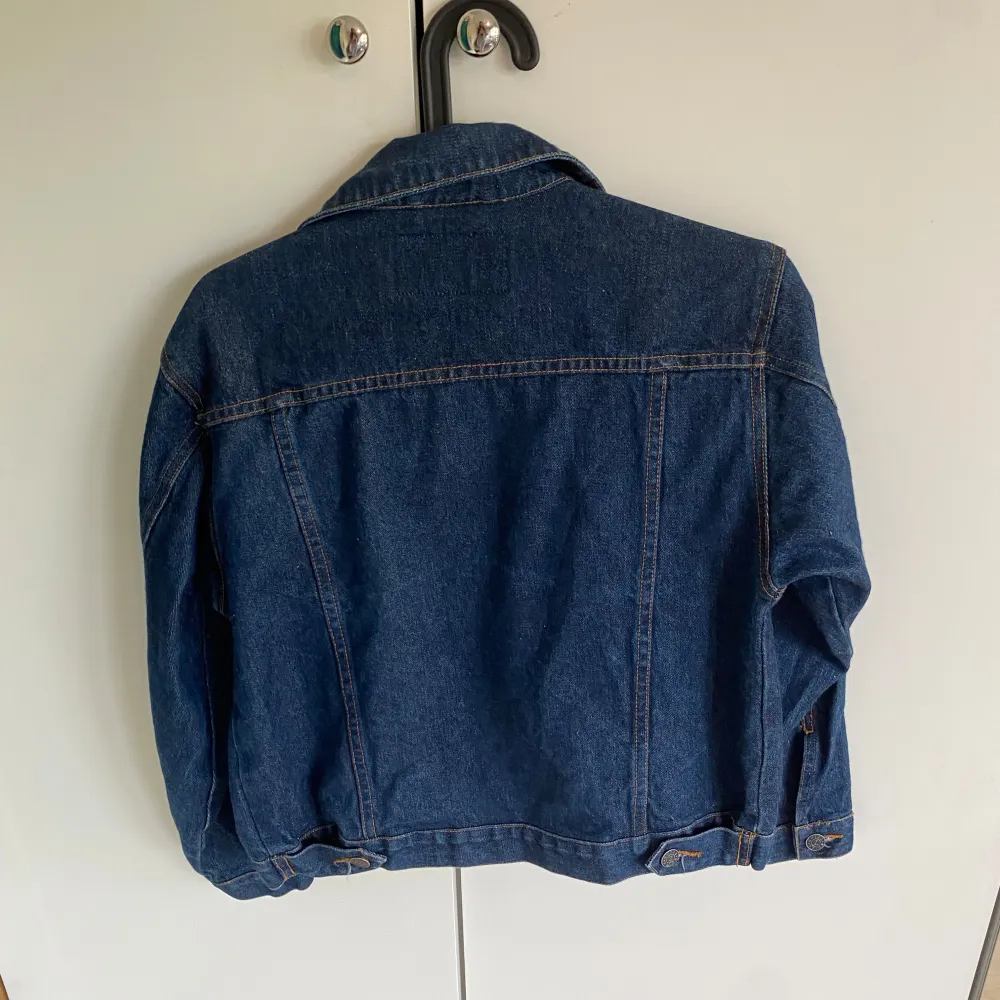 Säljer en klassisk blå jeansjacka från Jeanswear. Den har en snygg och tidlös design med knappar framtill och två bröstfickor med knappstängning. Jackan är i bra skick och perfekt för både vår och höst. Passar till nästan allt i garderoben!. Jackor.