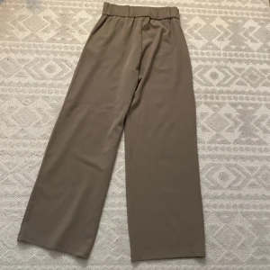 Beige vida byxor från JDY - ONLY - Säljer ett par superbekväma och stilrena beige vida byxor från JDY. De är högmidjade och har en loose passform som gör dem perfekta för både vardag och fest. Materialet känns mjukt och lyxigt, vilket ger en snygg look. Perfekta för höst och vår!