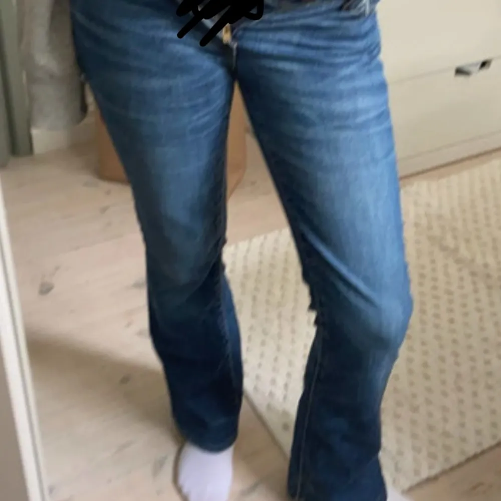 Säljer ett par snygga blå bootcut jeans från Levi's. De har en klassisk femficksdesign och är i en härlig blå färg med lätt slitna detaljer. Perfekta för en avslappnad vardagslook! Lågmidjade utsvängda bootcut. Jeans & Byxor.