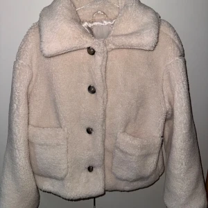 Teddyjacka - Krämvit teddyjacka i mycket bra skick. Storlek 36/S. Siden material inuti. Stängs med knappar.