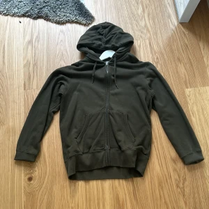 Mörkgrön Zip hoodie - Mörkgrön zip hoodie från uniqlo, använd 1 gång. 
