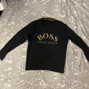 Svart/Guld Hugo Boss tröja  - Storlek L Sitter som en M