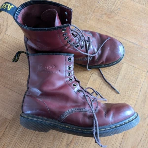 Röda kängor med snörning - Säljer ett par röda dr martens. De har en robust design med slitstark sula och är perfekta för höst och vinter.Storlek har försvunnit men det passar både 40 och 41 Se bilder för skada på sulan, går enkelt att fixa med lim. Inget som påverkar skon