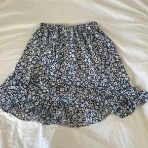 Blommig kjol - Längre blommig kjol med blommor och överlappning. Resår i midjan