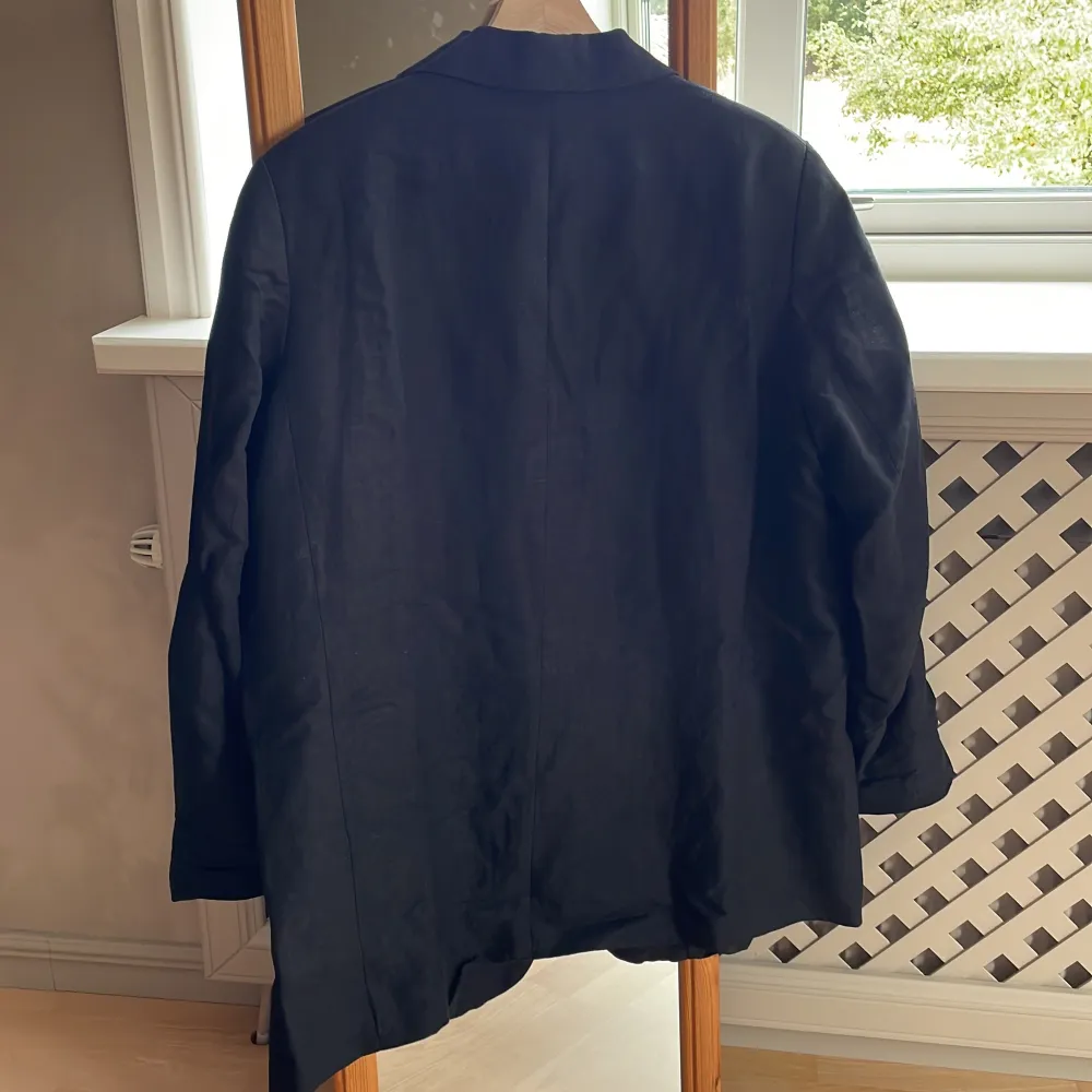 Svart oversized blazer från H&M i linneblandat tyg. Sitter supersnyggt på! Fejkfickor framtill, knäpps med en knapp. Superfint skick, säljer då den inte kommer till användning längre. . Kostymer.