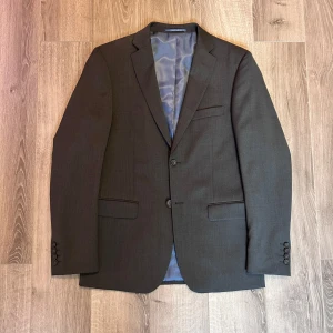 Kostym - Grå kostym från Dressman, köpt för några år sedan, använd 3 gånger. Kostymen är helt felfri och den snygga gråa färgen passar alla tillfällen. Nypris 1500.  Kavajen är i storlek 48 (slim fit) 