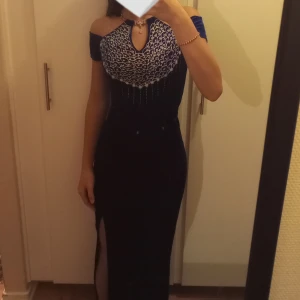 Festklänning  - Säljer denna ursnygga festklänning med slit och detaljer på. Står inte storlek, men den passar mig som har xs/s. Köparen står för frakten! 