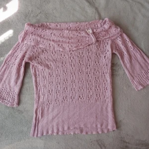 Rosa stickad offshoulder-tröja - Säljer en superfin rosa stickad offshoulder-tröja med trekvartsärmar. Den har ett snyggt mönster och en liten knappdetalj vid halsen. Perfekt för hösten! Kp för mer information🫶🏻💗