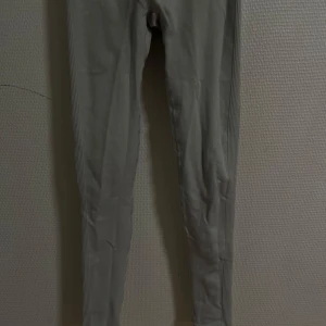 Grå leggings - Säljer ett par grå leggings i stretchigt material. De är tighta och har en ribbad midja som ger en bekväm passform. Perfekta för både träning och vardagsbruk!