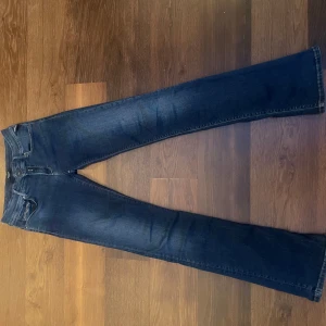 Blå jeans från Replay - Säljer ett par snygga blå low waist jeans från Replay i storlek Waist 28 och Längd 32. De har en mörkblå tvätt💙Jeansen är i väldigt bra skick och har en bekväm passform!✨