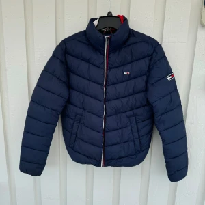 Elegans jacka från Tommy Hilfiger  - Jacka från Tommy Hilfiger Använd endast 2 gånger, i utmärkt skick – nästan som ny! Marinblå färg, klassisk och stilren design. Storlek XS. Längd: 58 cm Bredd: 52 cm Ordinarie pris: 2199 kr, men nu säljs den för endast 599 kr!  Ett fantastiskt tillfäl