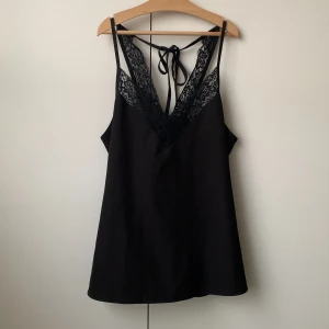 Svart spetslinne  - Svart linne med spets och snörning i ryggen. Passar även M.