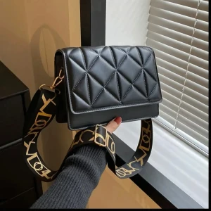 Svart quiltad axelväska - Snygg svart axelväska med quiltat mönster och justerbar axelrem med guldiga detaljer. Perfekt för både vardag och fest! 🖤 helt ny