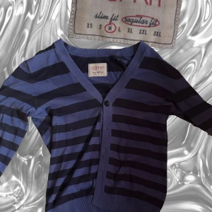 Blå och svart randig kofta från Esprit - Säljer en snygg randig kofta från Esprit. Den har en v-ringad design med knappar framtill Koftan är i regular fit och har långa armar. Passar perfekt till höst!