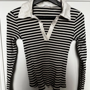 Randig långärmad tröja med krage - Säljer en superfin randig tröja i svart och vit med en snygg krage. Den är ribbad och har långa ärmar, perfekt för höst och vår. Endast använd en gång, perfekt skick. 