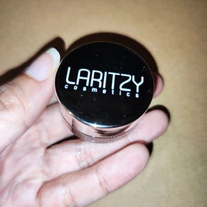 Laritzy Cosmetics Dew Pot i nyansen Glory - Säljer en Laritzy Cosmetics Dew Pot i den skimrande nyansen Glory. Perfekt för att ge ansiktet en strålande glöd. Kommer i en smidig liten burk som är lätt att ta med sig. Använd den som highlighter för att framhäva dina bästa drag!