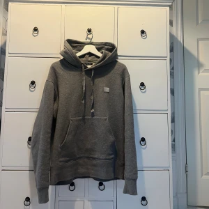 Acne Studios Hoodie - Säljer nu denna gråa acne hoodie pga fel storlek. Kvaliten och färgen är klinisk på tröjan och den är även sparsamt använd. Storleken är S men passar M då den är lite oversized. Hör gärna av dig vid funderingar👏