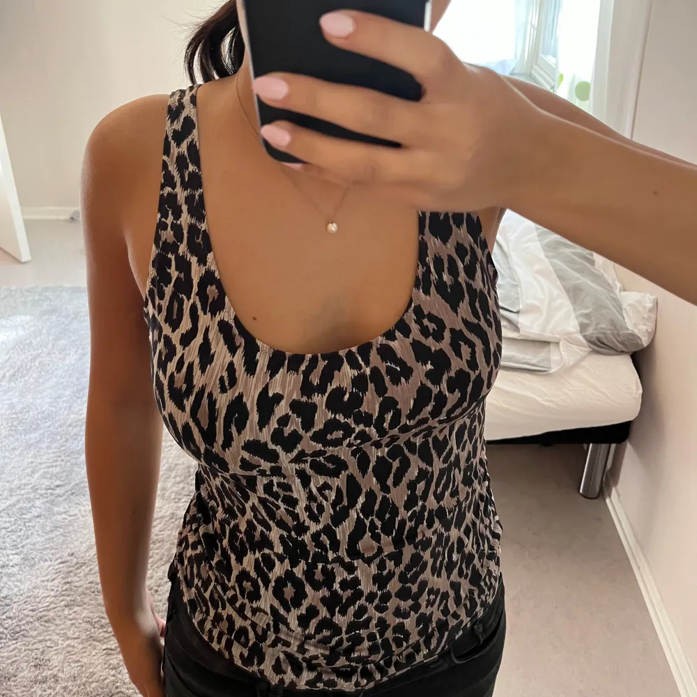 Snygg leopardmönstrad linnetopp från Dolce & Gabbana. Toppen är ärmlös och har en tight passform, perfekt för en utekväll eller fest. Materialet känns lyxigt. Passar perfekt till svarta jeans. Storleken passar mig som brukar ha S. Använd fåtal gånger. Toppar.