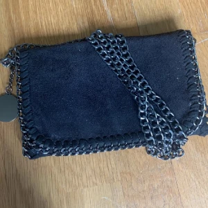 Väska  - Liten axelbandsväska med kedjor. Den är svart och lite glittrig. Säljer då den inte kommer till användning längre. ❤️Skriv om ni har några frågor eller vill ha fler bilder❤️