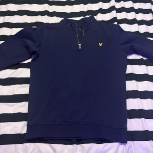 Mörkblå tröja från Lyle & Scott - Säljer en stilren mörkblå tröja från Lyle & Scott med dragkedja vid halsen och ett litet gult emblem på bröstet. Perfekt för en avslappnad stil. Har använt den några gånger. Pris 450  men priset kan diskuteras vid affär! Skriv gärna om du är intresserad 