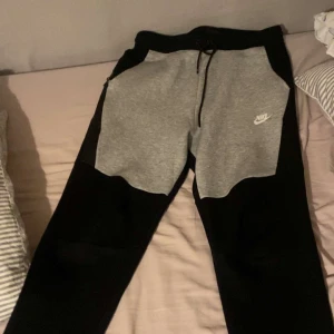 Grå och svarta mjukisbyxor från Nike - Nike tech byxor