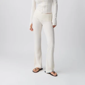 Vita Yogapants byxor - Snygga vita bootcut yogapants med låg midja. Perfekta för en stilren look, dessa byxor har en skön passform och är tillverkade i ett mjukt material.