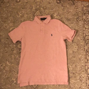 RL piké - Säljer nu dessa as fräscha piké från Ralph Lauren den är köpt förra sommaren för 1200 och är knappt använd| den är i mottled rosa färg med marinblå detaljer och är i storlek S| skriv om ni har några funderingar!😁