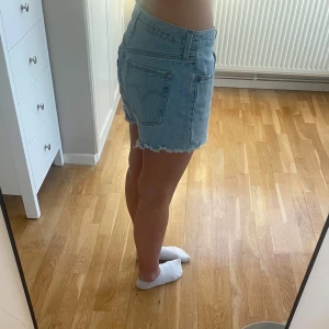 Jeansshorts från Levi's - Säljer ett par ljusa 501 Levi's jeansshorts med fransiga kanter och klassisk femficksdesign. Perfekta för sommardagar. Midjemått 40,5cm rakt över 