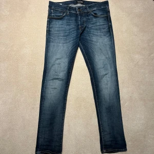 Jack&Jones Jeans  - Snygga blå jeans med en slim passform och klassisk femficksdesign. De har en dragkedja och knapp framtill. Perfekta för en stilren look. Vid minsta fråga eller fundering hör av er🤝