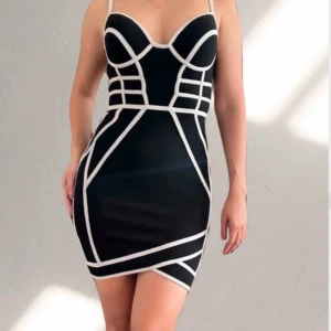 Svart klänning  - En svart klänning med vita detaljer. Klänningen har en dragkedja längs ryggen och justerbara band. Pris kan diskuteras