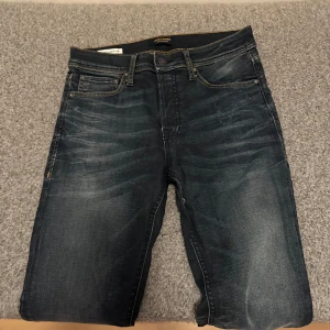 Mörkblå jeans från Jack & Jones - Snygga mörkblå jeans från Jack & Jones med klassisk femficksdesign och knappgylf. Perfekta för en avslappnad stil under varma dagar. 28/30 använda ca 10 gånger modell slim fit glen