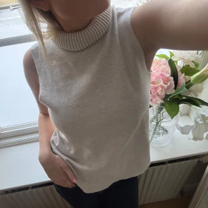 Zara topp - Snygg vit ärmlös polotopp med ribbad krage. Perfekt för lager-på-lager eller som den är under varmare dagar.