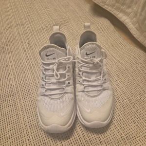 Vita Nike Air Max sneakers - Säljer ett par stilrena vita Nike Air Max sneakers. Skorna har en klassisk design med snörning och en bekväm sula. Perfekta för en sportig look.