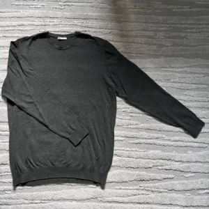 Mörkgrå tröja från Zara - Säljer en stilren mörkgrå tröja från Zara. Tröjan har en klassisk design med långa ärmar och rund hals. Köpte för 350 men har inte användit alls då den var för liten. Perfekt för en trendig look. Står storlek L men passar M i storleken.💯