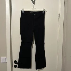 Svarta byxor från Zara - Snygga svarta byxor från Zara med bootcut-stil. De har en knapp och dragkedja framtill. Perfekta för en stilren look.