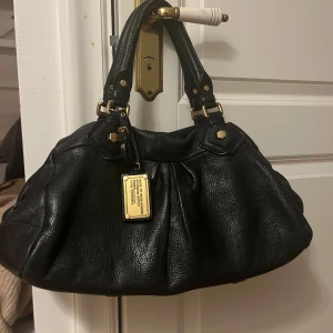 Marc Jacobs väska  - Marc Jacobs väska från classic q collection köpt från Vestiaire Collective! Bra skick bortsett från slitning på ena handtaget men inget som syns tydligt. Fläcken på sista bilden fanns där när jag köpte! Kan oxå tänka mig att byta till den mindre versionen!! Hör av dig om frågor elr fler detaljerade bilder o skriv INNAN du trycker på köp nu ❤️❤️