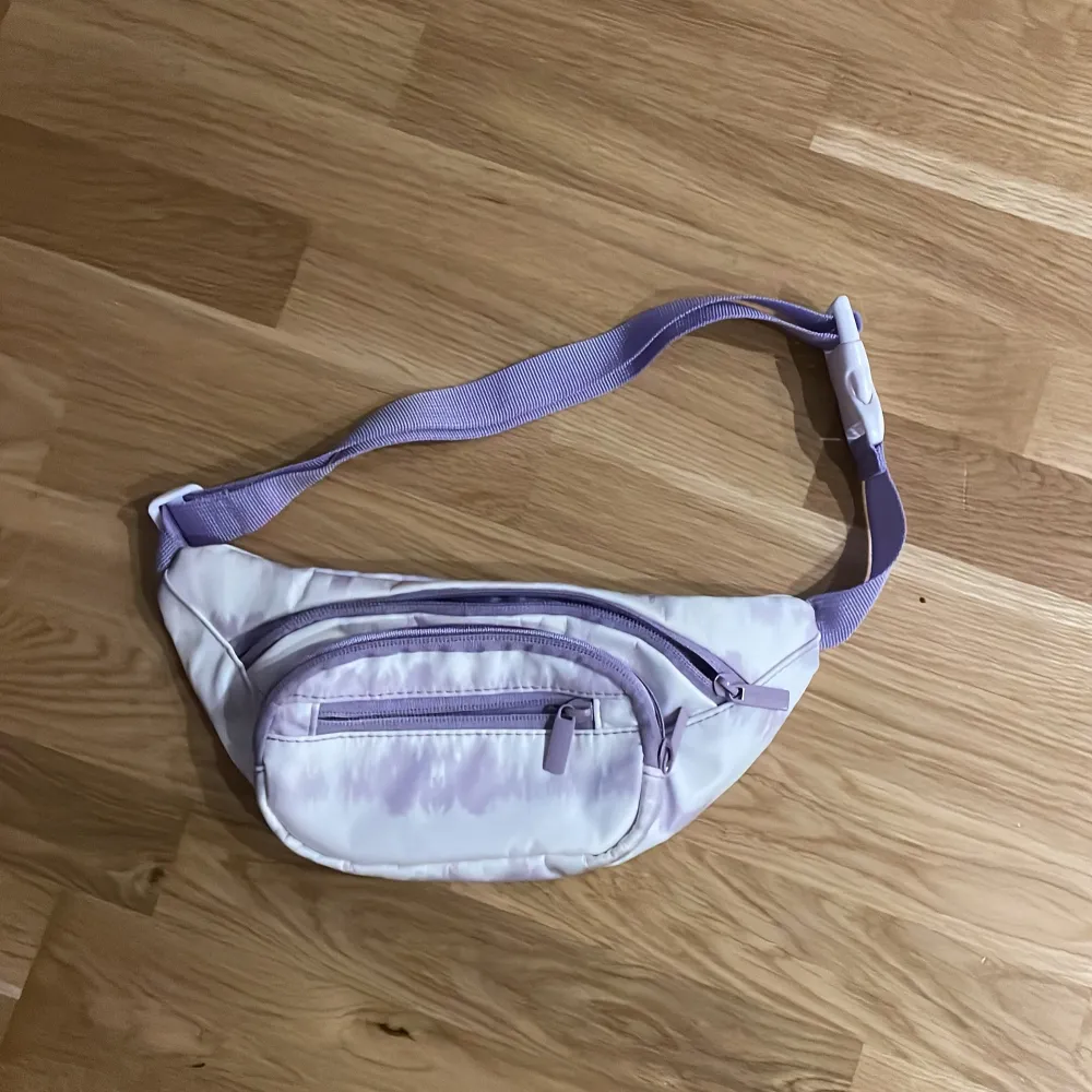 Säljer en Lila/vit Magväska. Den har tre fack med dragkedja. Väskan är i mycket bra skick och använd ett fåtal gånger. 💕. Laukut & Käsilaukut.