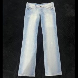 Lågmidjade ljusblå raka jeans från Diesel - Snygga väldigt lågmidjade ljusblå jeans från Diesel med en klassisk femficksdesign och dekorativa nitar vid fickorna. Jeansen har en straight passform, mått finns på bilderna 🩷