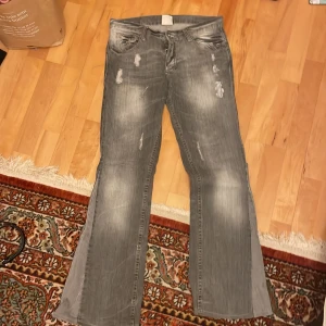Grå bootcut jeans - Säljer ett par grå bootcut jeans i bra skick. De har en snygg slitning på framsidan och är lågmidjade. Perfekta för en avslappnad stil och passar bra till både vardag och fest. Storlek dam M. Lite långa på mig som är 170/171, säljer pga förstora💖 pris kan diskuteras, skriv om fler bilder eller prisförslag💖 40cm rakt över i midjan🩷