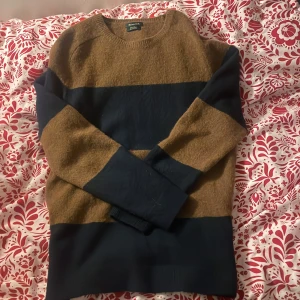 Brun och marinblå tröja från Massimo Dutti - Snygg tröja från Massimo Dutti i brunt och marinblått. Den har ett randigt mönster och är tillverkad i ullblandning. Perfekt för kyligare dagar med sin långärmade design.