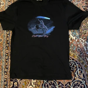 Svart t-shirt med tryck - Snygg svart t-shirt med ett coolt tryck av en ryttare och en komet. Perfekt för en avslappnad stil. Kortärmad och i mjukt material.