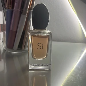 Si från Giorgio Armani - Elegant parfymflaska från Giorgio Armani med doften Si. Flaskan är genomskinlig med en svart kork. 30 ml och bara testad