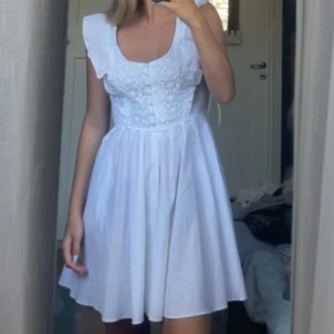 Vit klänning med spetsdetaljer - Säljer denna helt oanvända klänningen från NA-KD i stl. Xs-S som jag köpte för 3 år sedan men har tyvärr aldrig kommit till användning. Den har superfina detaljer såsom volanger och spets detaljer + fickor som inte syns. Skriv för fler bilder då dessa är tagna för länge sedan. Perfekt klänning till sommaren eller som studentklänning🥂🎉💕(lite genomskinlig) Nypris: 800kr