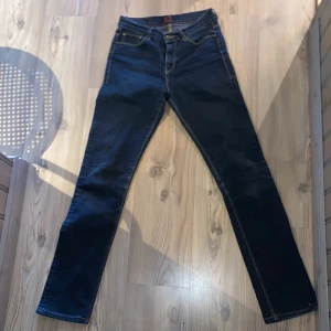 Blå jeans från Crocker - Snygga blå jeans från Crocker med klassisk design och gul söm. De har en knapp och dragkedja framtill samt fem fickor. Perfekta för en avslappnad stil.