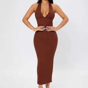 Brun ribbad klänning - Snygg brun ribbad klänning med djup v-ringning och öppen rygg. Klänningen är ärmlös och har en tight passform som framhäver figuren. Perfekt för en stilren och elegant look. Endast använd 1 gång 💗