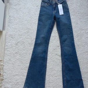 Blå bootcut jeans - Snygga blå bootcut jeans med låg midja. Helt nya och oanvända med lapp kvar.
