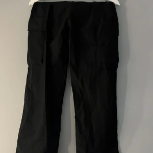 Svarta cargopants med fickor - Snygga svarta cargopants med fickor på sidorna. Byxorna har en loose passform och är perfekta för en avslappnad stil.
