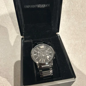 Svart klocka från Emporio Armani - Säljer min Emporio Armani klocka som är svart pågrund av att jag ångra mitt köp och använder inte den. Har boxen kvar till klockan. Skriv privat för fler bilder. Kan ner i pris vid snabb affär