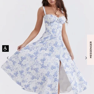  klänning från House of CB/ CARMEN dress🩵 - Säljer en vacker vit klänning med blått blommönster från House of CB. Klänningen har en smickrande snörning framtill och en elegant slits, storlek S används en gång! Helt ny!!! ❤️original pris 2800kr. Min pris 2000// Perfekt för sommarens alla tillfällen!🌸